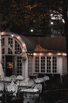 A cozy boutique hotel terrace decorated with warm lights and elegant outdoor seating.