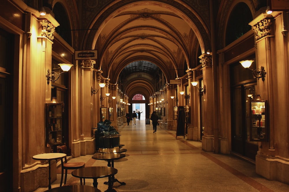 a long hallway with tables and lamps on either side of it
