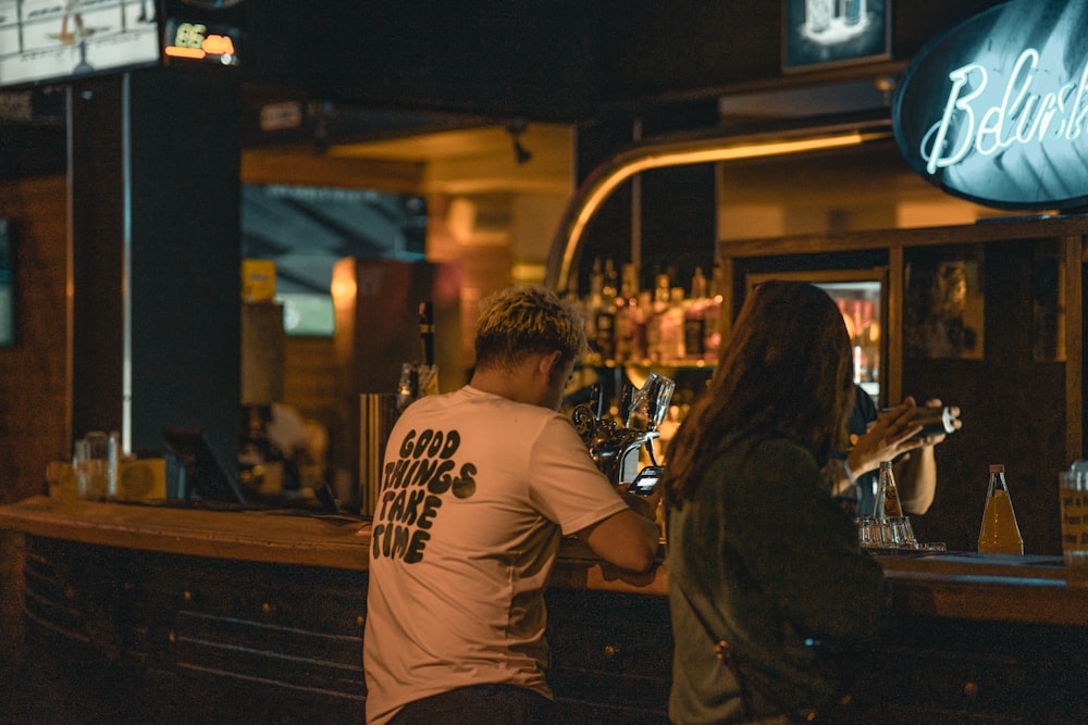 a man and a woman standing at a bar