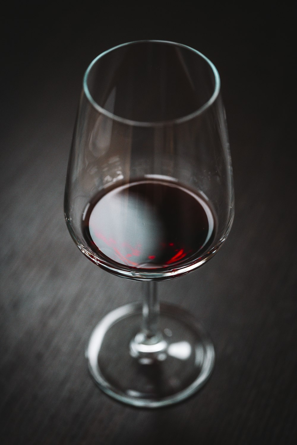 a glass of red wine sitting on a table