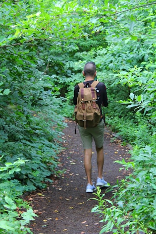 Local guide walking along a narrow path through thick Cambodian jungle
