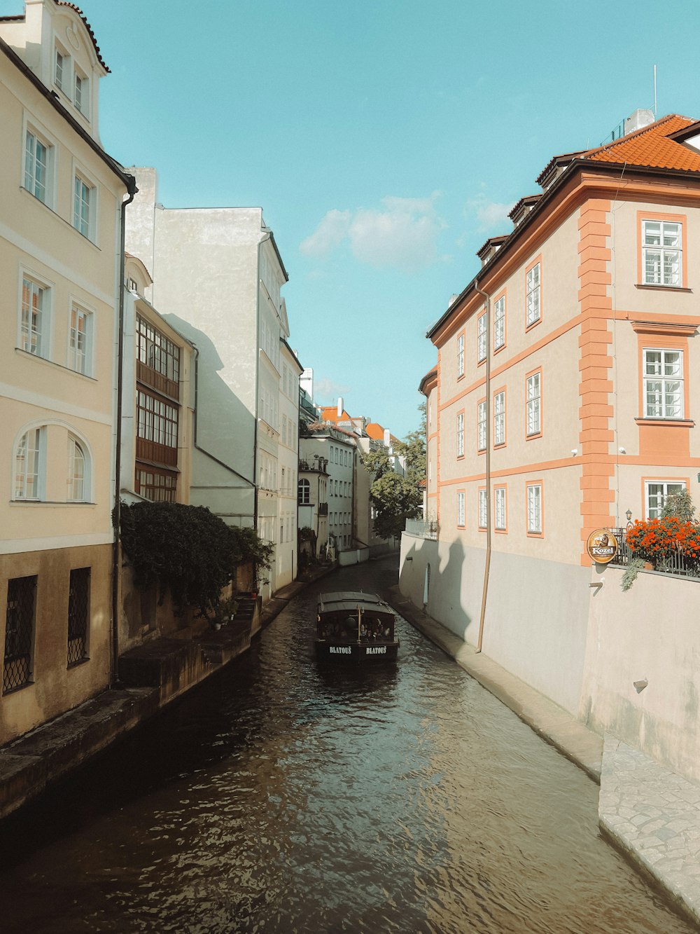 a boat traveling down a river next to tall buildings