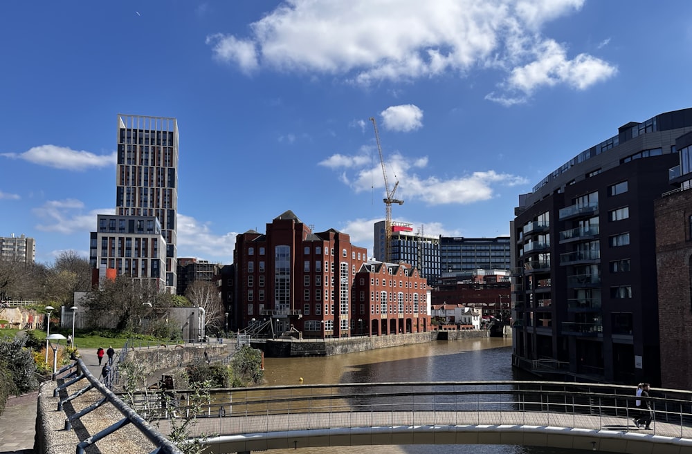 a bridge over a body of water with buildings in the background