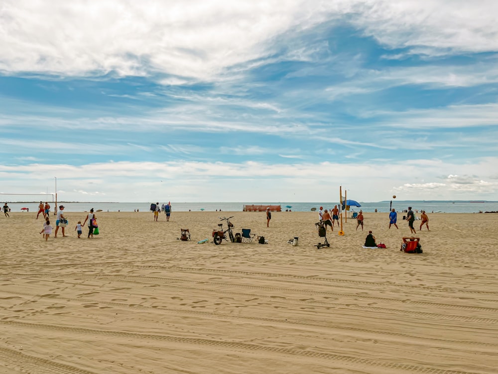 a group of people standing on top of a sandy beach