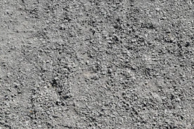 Close-up of compacted gravel with tractor tire tracks showing the finish