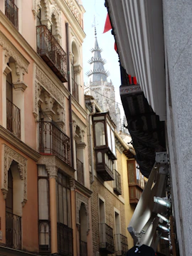 A lively street in Córdoba filled with small businesses displaying promotional banners.