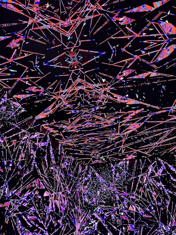 An abstract digital artwork featuring a multitude of intersecting geometric shapes and lines in vivid colors against a dark background. The overlapping forms create a sense of depth and motion, with vibrant shades of red, blue, pink, and purple standing out prominently.