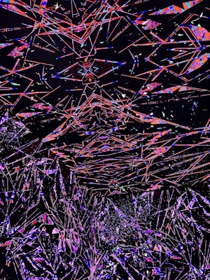 An abstract digital artwork featuring a multitude of intersecting geometric shapes and lines in vivid colors against a dark background. The overlapping forms create a sense of depth and motion, with vibrant shades of red, blue, pink, and purple standing out prominently.