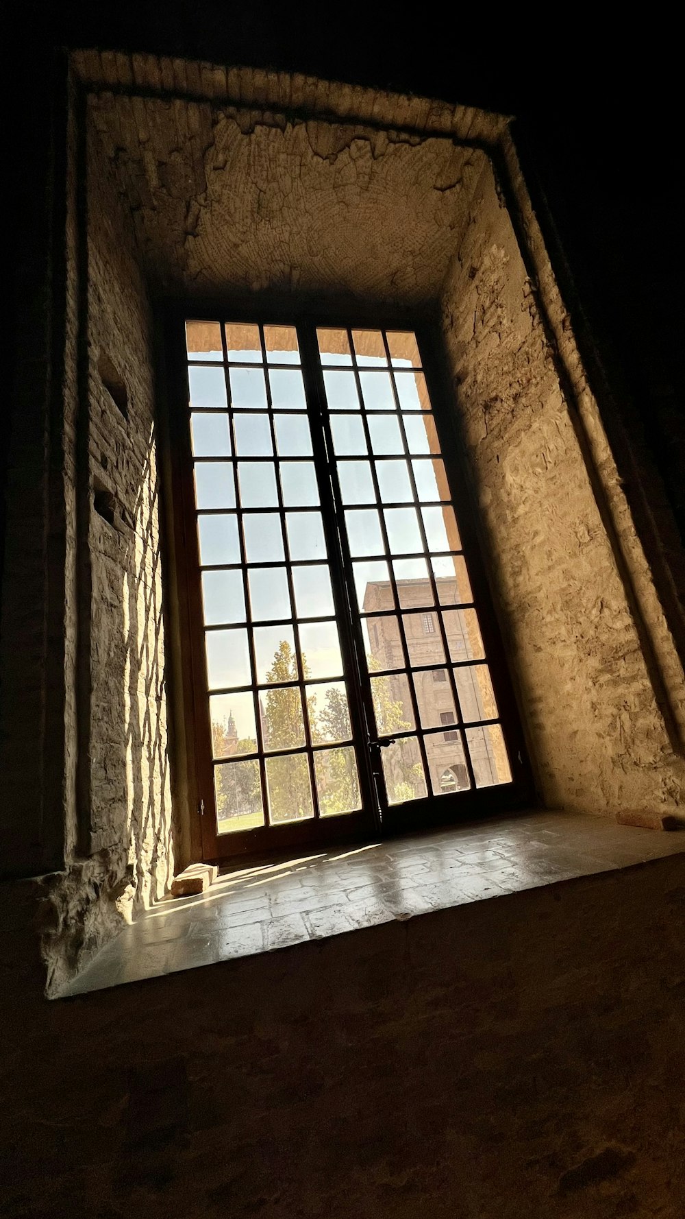 a window in a stone building with a light coming through it