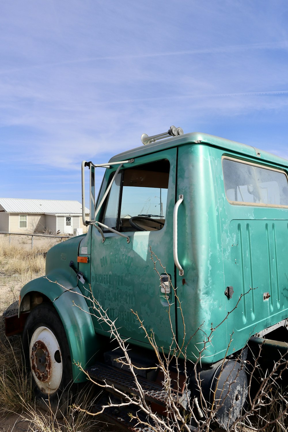 an old green truck parked in a field