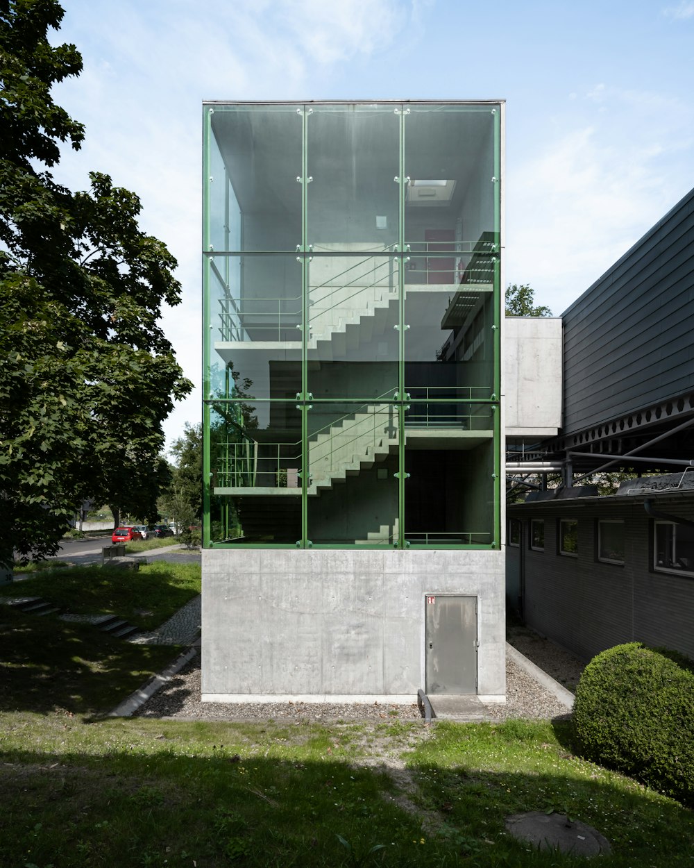 a tall building with a green glass window on top of it