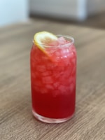 A refreshing glass of iced beverage on a wooden table.