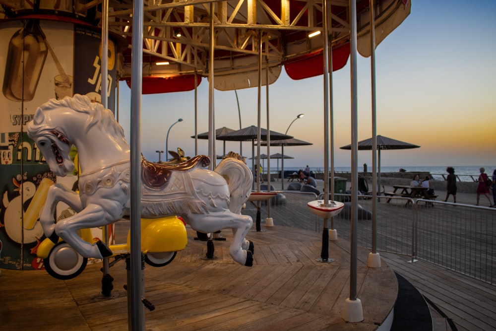 a merry go round on a pier with umbrellas