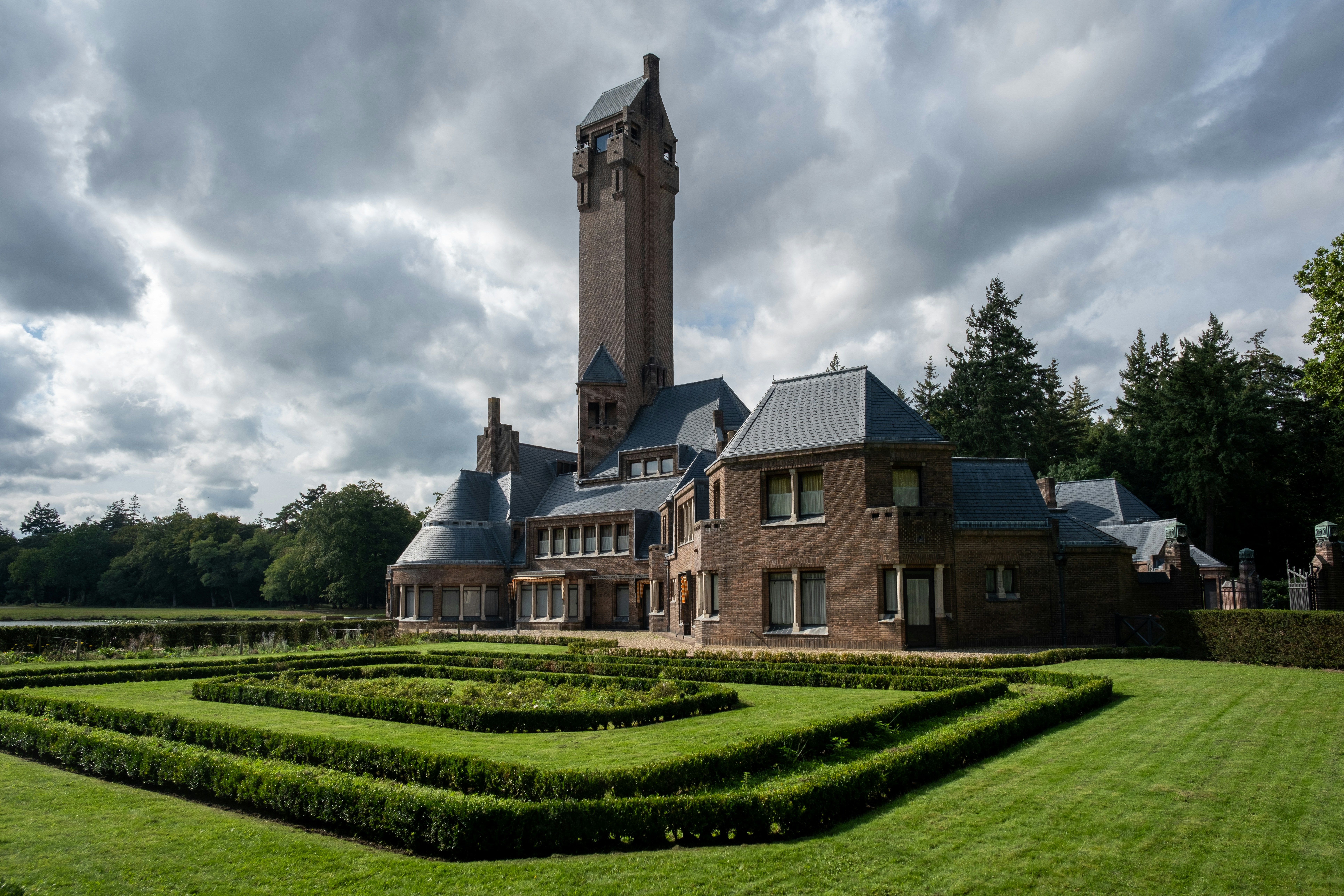 a large building with a clock tower in the background, St. Hubertushuis at The Veluwe,, a grand wildlife-park in Holland