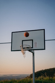 a basketball is in the air above a basketball hoop
