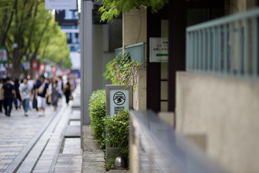 a group of people walking down a street next to tall buildings