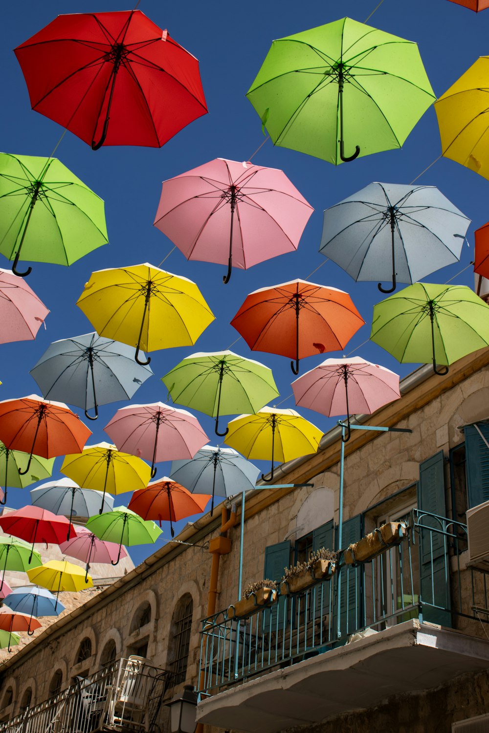 a group of multicolored umbrellas flying in the air