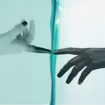 Two hands are depicted reaching towards each other with only their fingertips touching, separated by a transparent barrier. The left hand appears to be in a black and white style, while the right hand has a darker tone against a pale turquoise background.