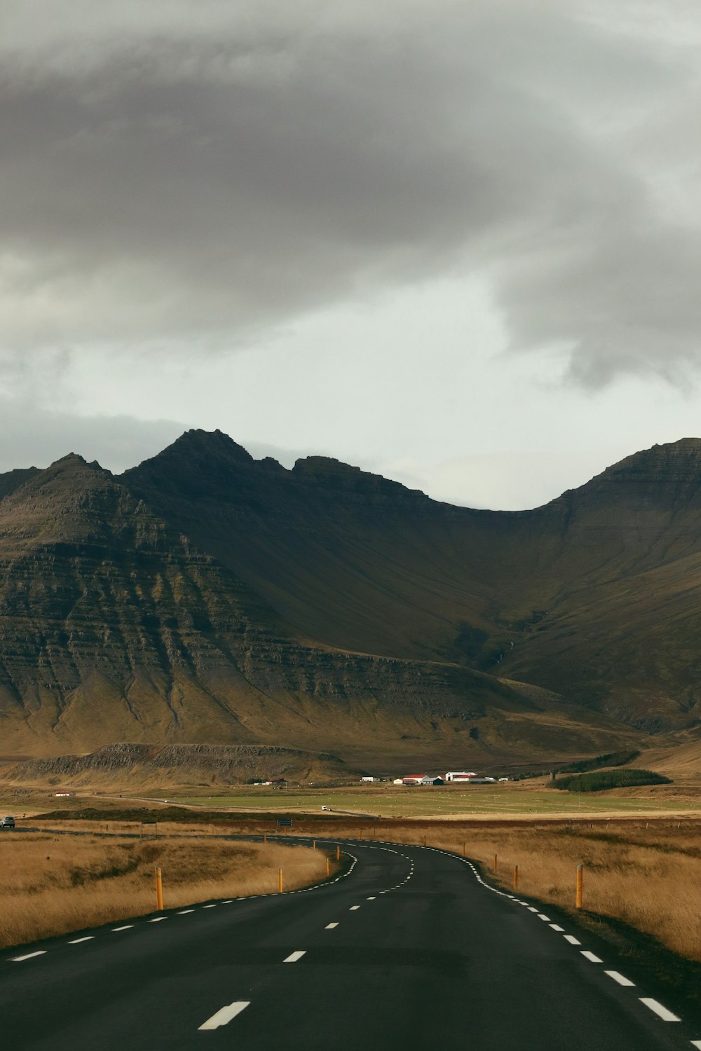 an empty road with a mountain in the background