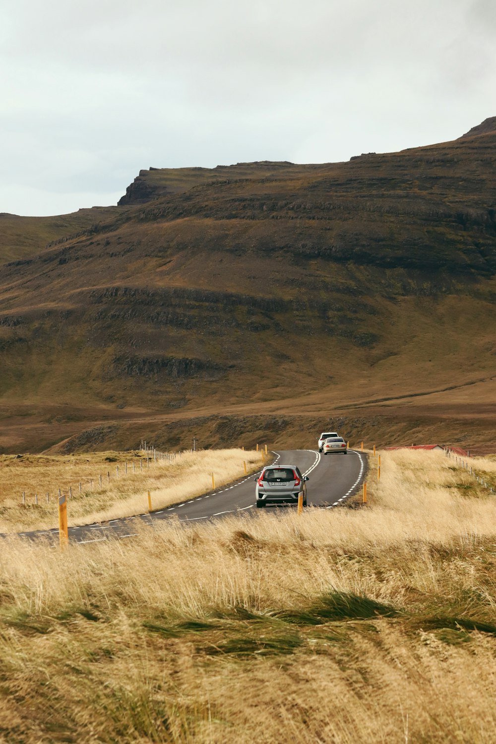 a couple of cars driving down a curvy road