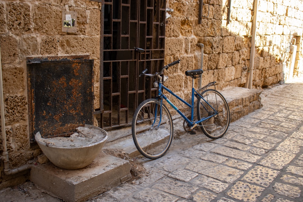a blue bike parked next to a stone building