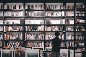 A bookshelf adorned with literary awards and framed author photographs.