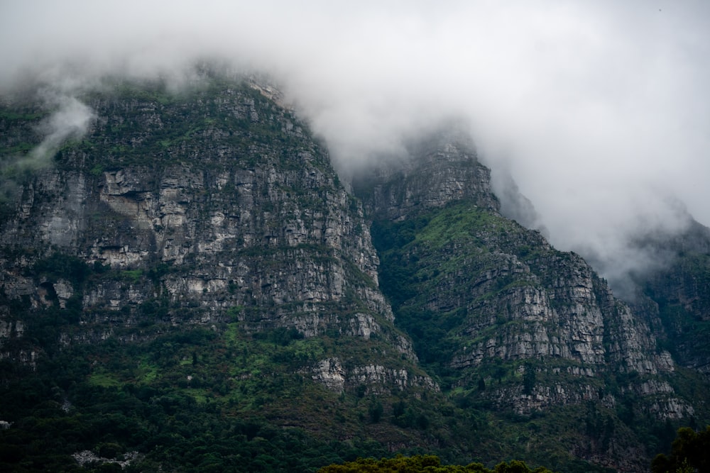 a very tall mountain covered in clouds and fog