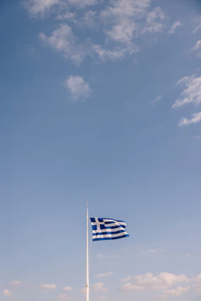 The flag of Acre state waving gently against a clear blue sky.