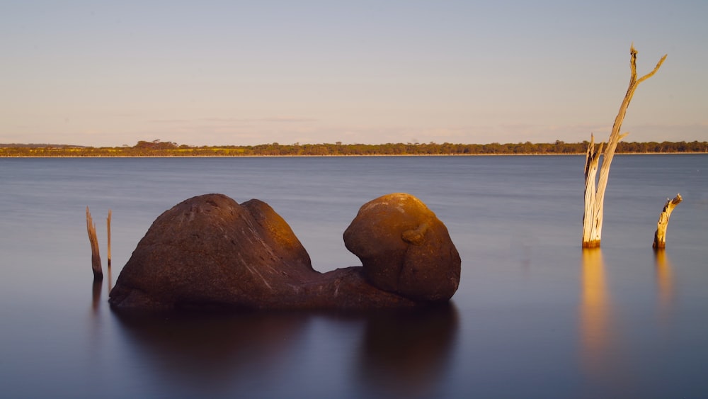 a large rock sitting in the middle of a lake