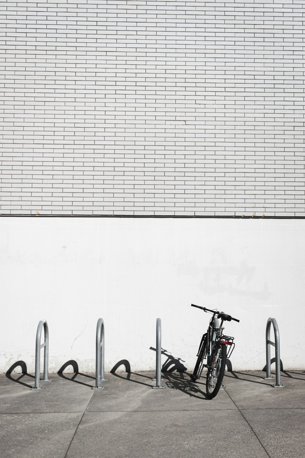 a bicycle leaning against a wall with a bike rack