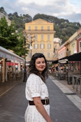 a woman in a white dress standing on a street