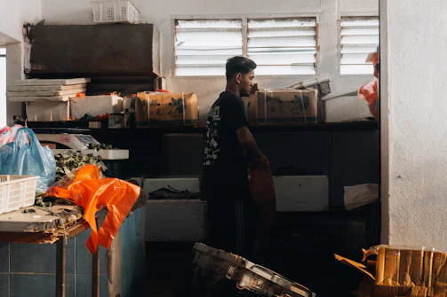 A professional mover carefully packing boxes in a bright, tidy living room.