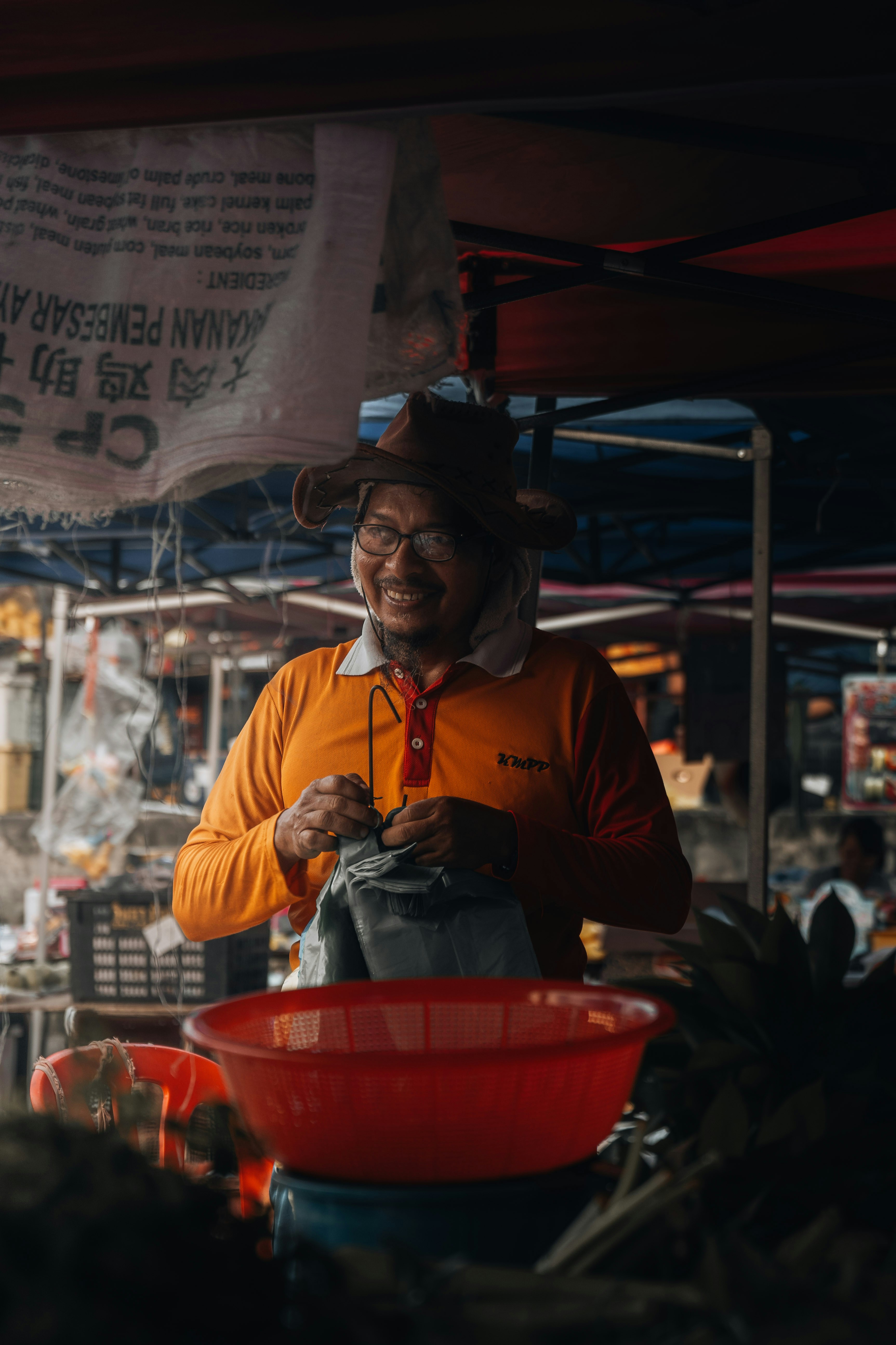 seorang pria dengan kemeja oranye dan mangkuk merah