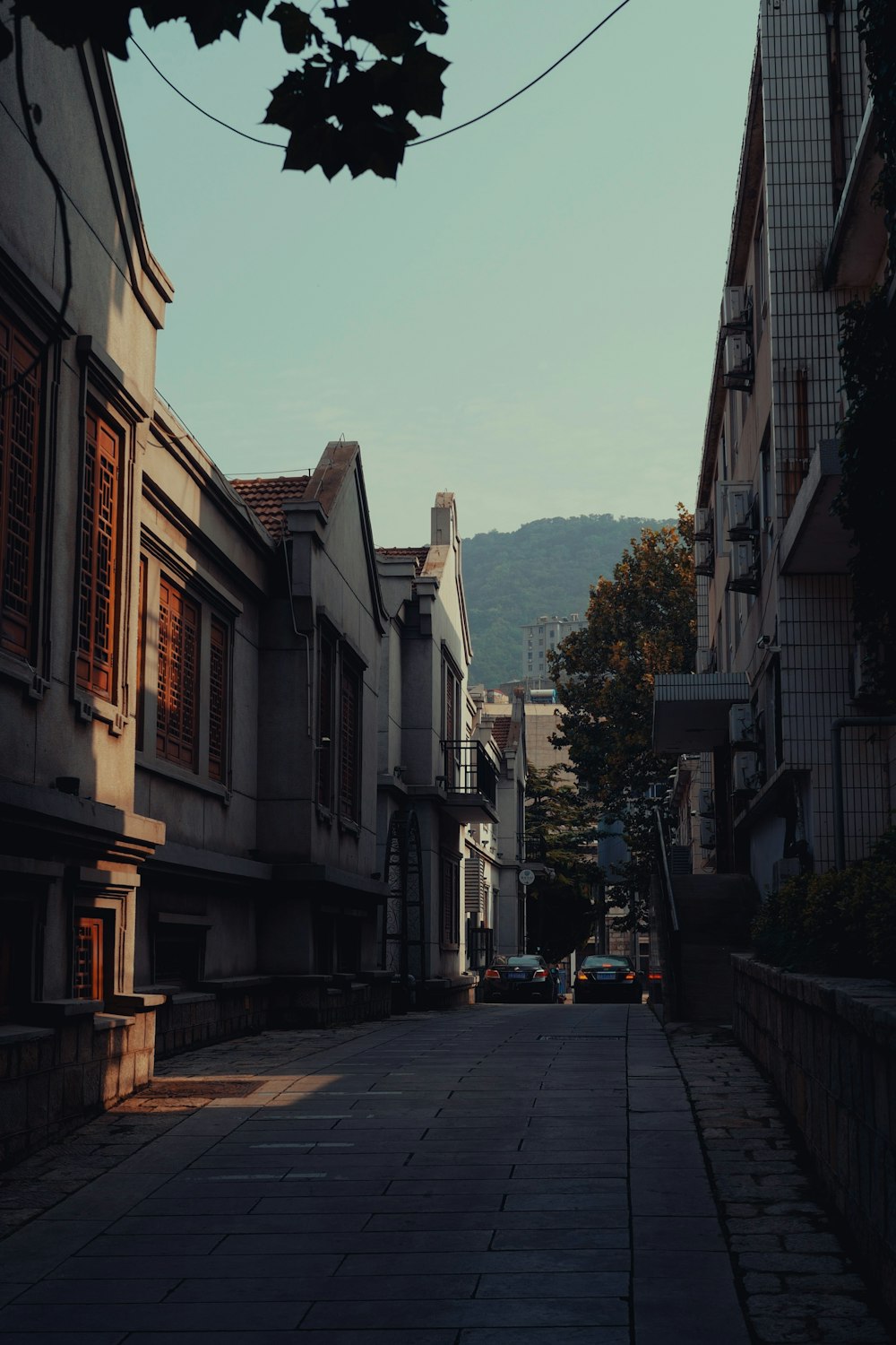 a narrow street with buildings and a clock tower in the distance