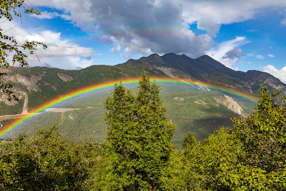 a rainbow in the sky over a mountain range