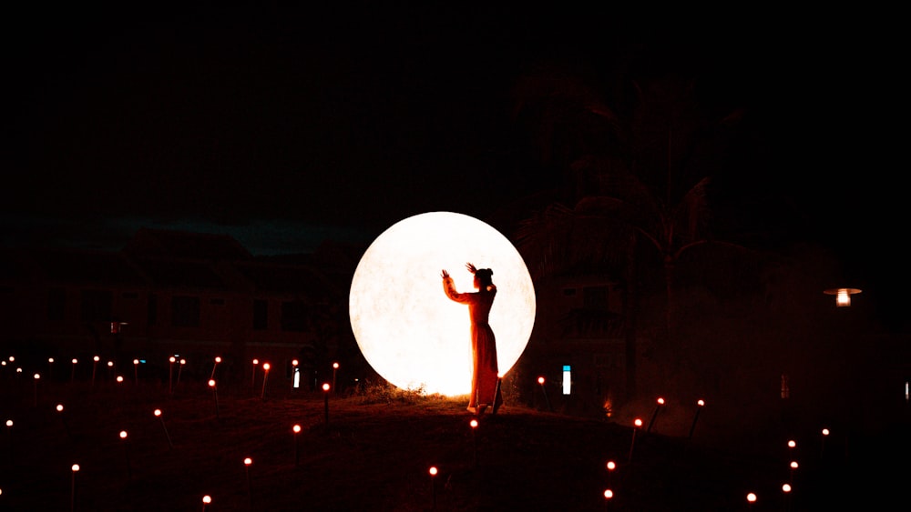 a person standing in front of a large white ball