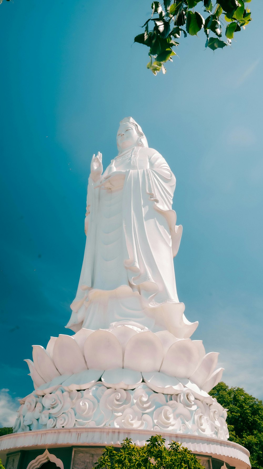 a large white statue with a sky background