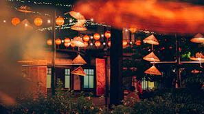 An inviting outdoor seating area decorated with traditional Vietnamese lanterns at dusk