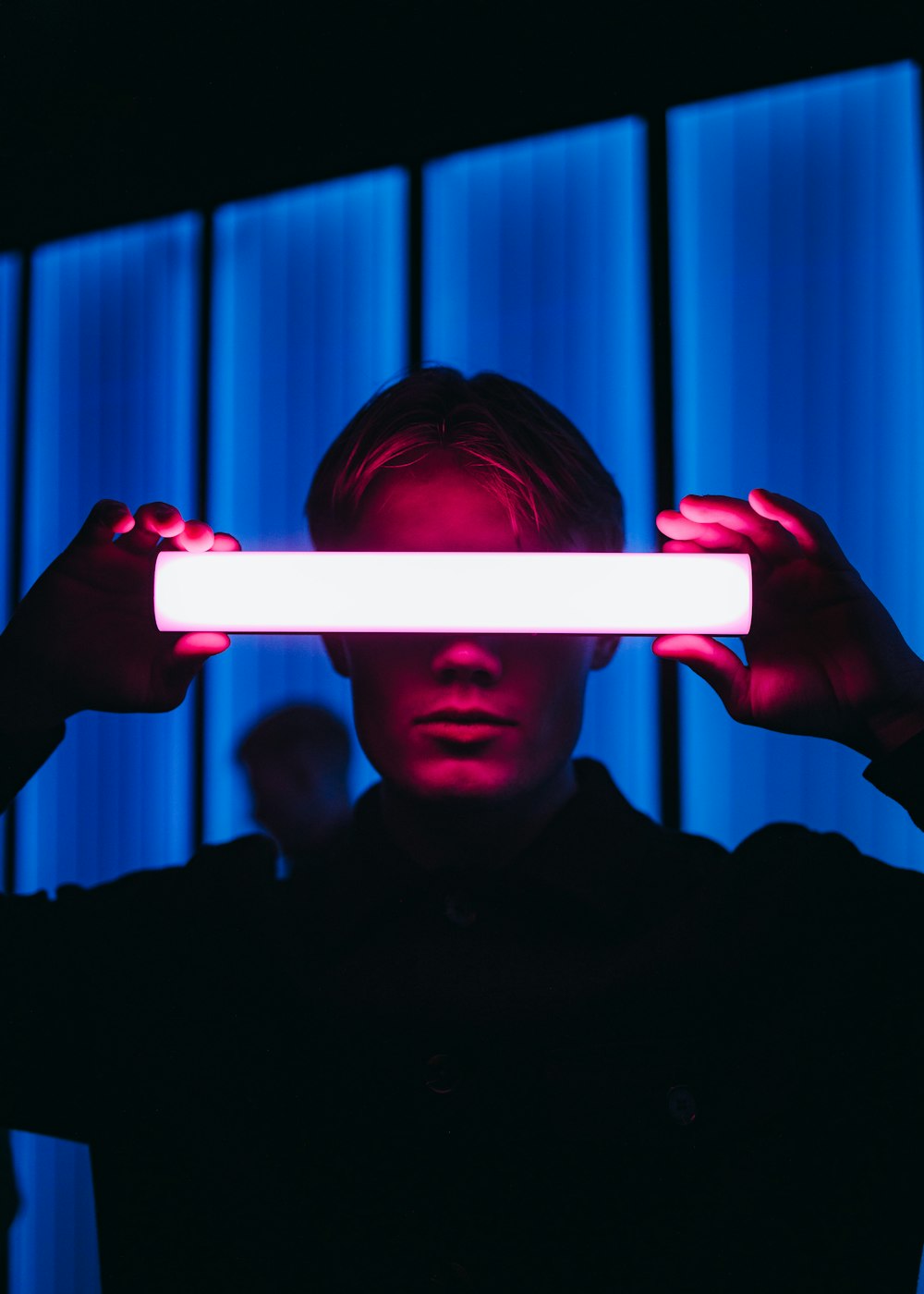 a man holding a light up in front of his face