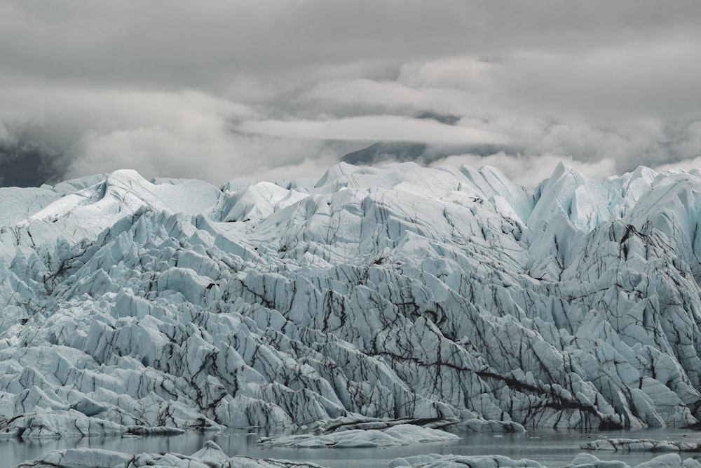 a large glacier with mountains in the background