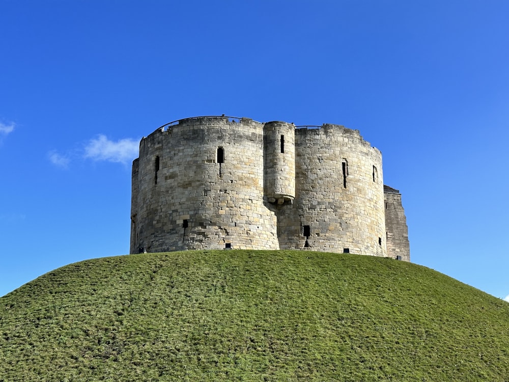 a tall castle sitting on top of a lush green hillside