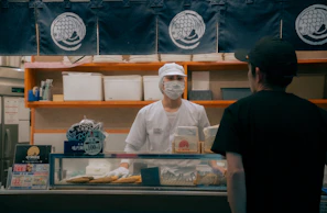 Friendly staff member assisting a customer at the bright, clean service counter.