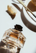 Someone layering different perfume sprays on wrist and neck, smiling softly in a sunlit room