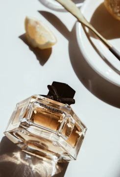 Close-up of a creator’s hands unboxing a beautifully designed perfume package, with soft natural light highlighting the details.