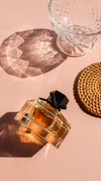 a bottle of perfume sitting next to a glass bowl