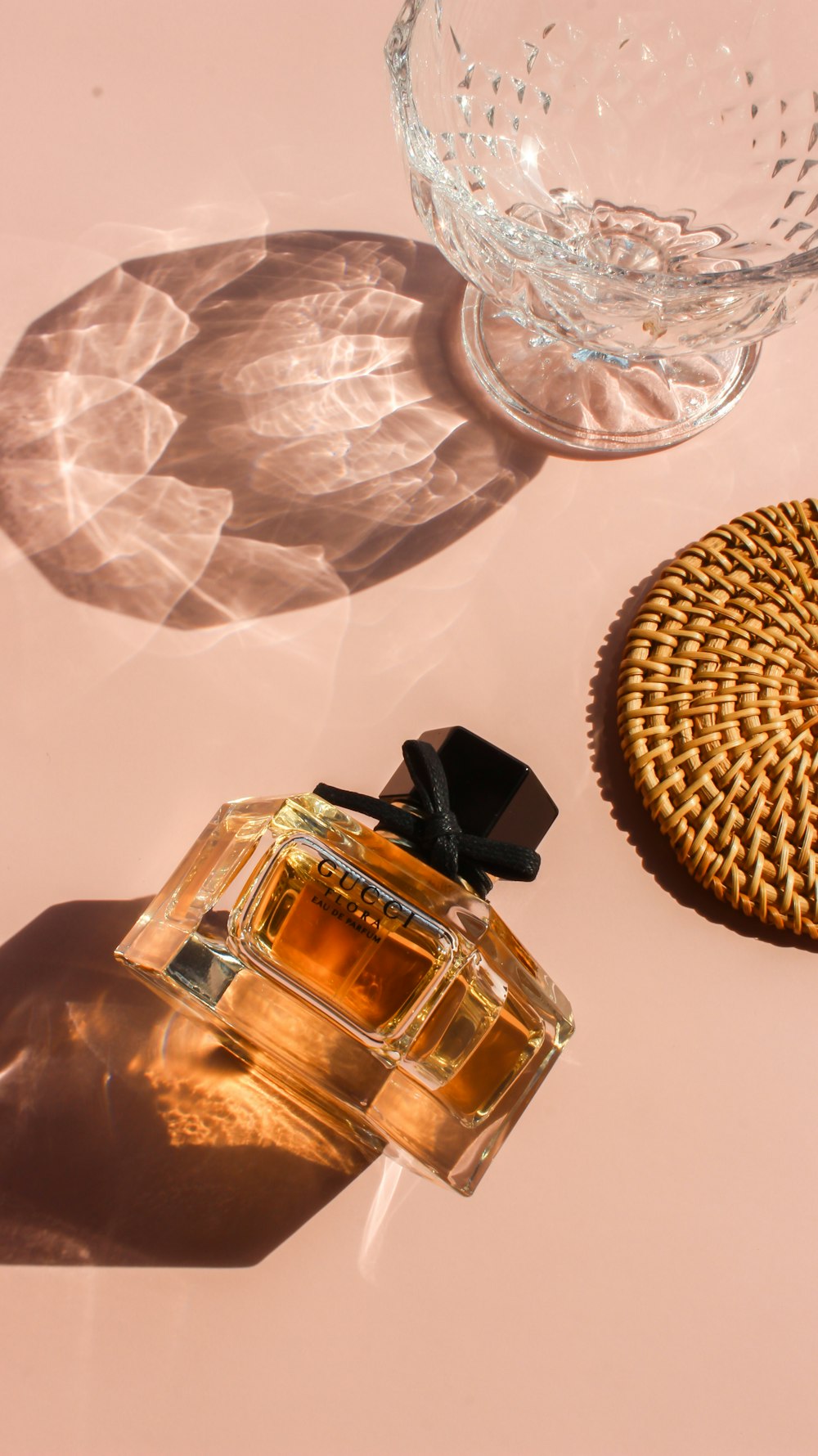 a bottle of perfume sitting next to a glass bowl