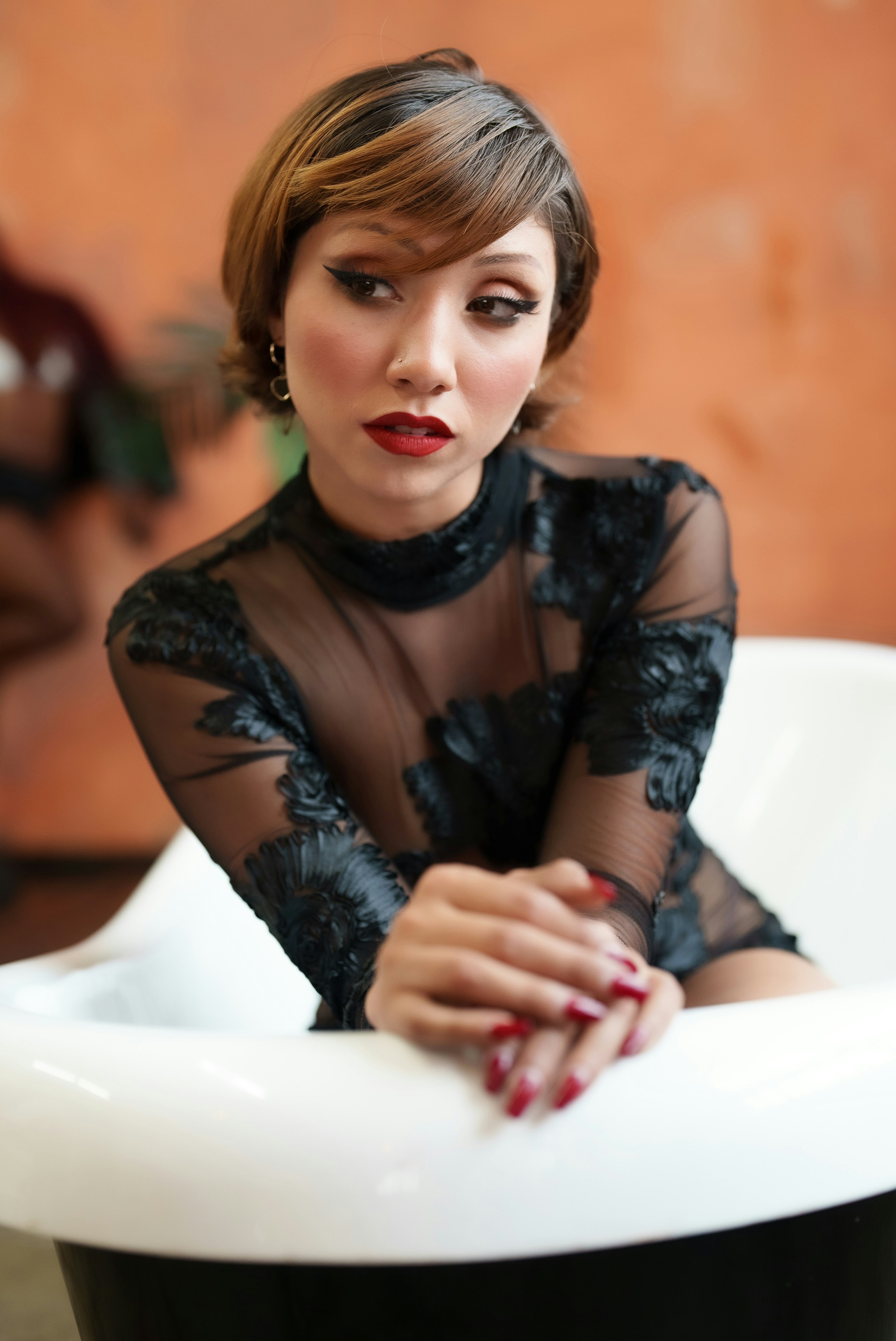 a woman in a black dress sitting in a chair