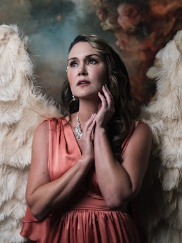 A stunning female fallen angel with glowing wings, her expression both alluring and mysterious, set against a dark, celestial backdrop.