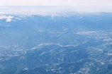 Aerial shot of Monte Verde’s green mountains and winding trails on a clear day
