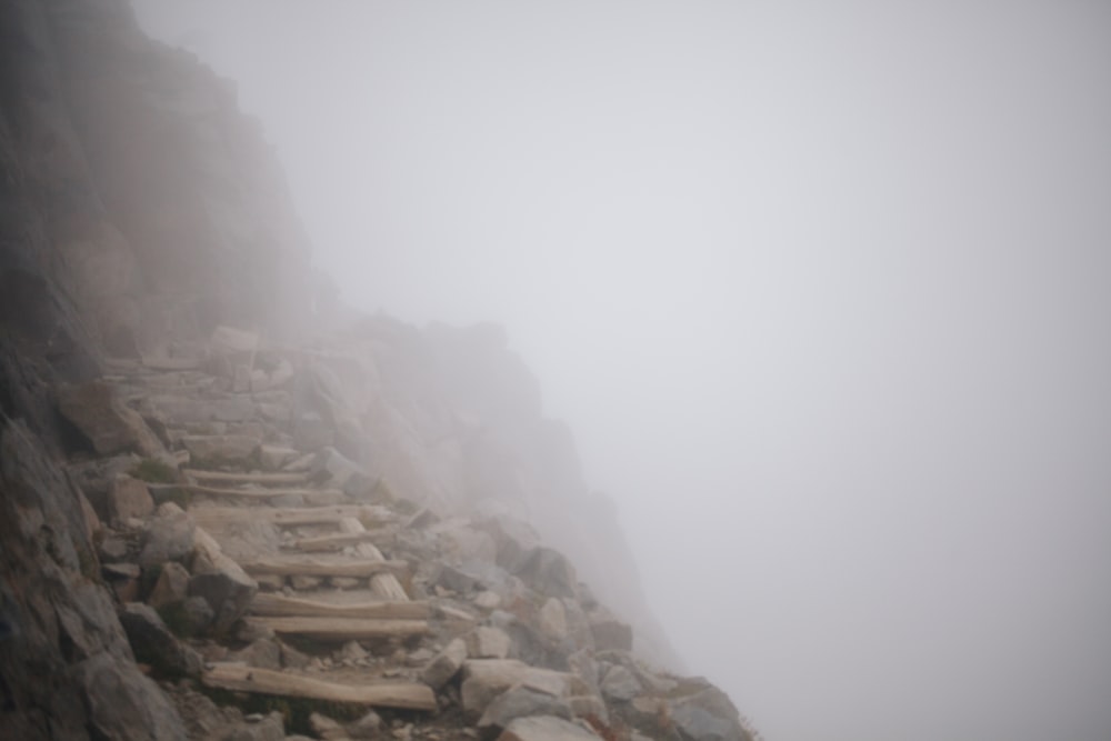 a foggy mountain side with stairs and rocks